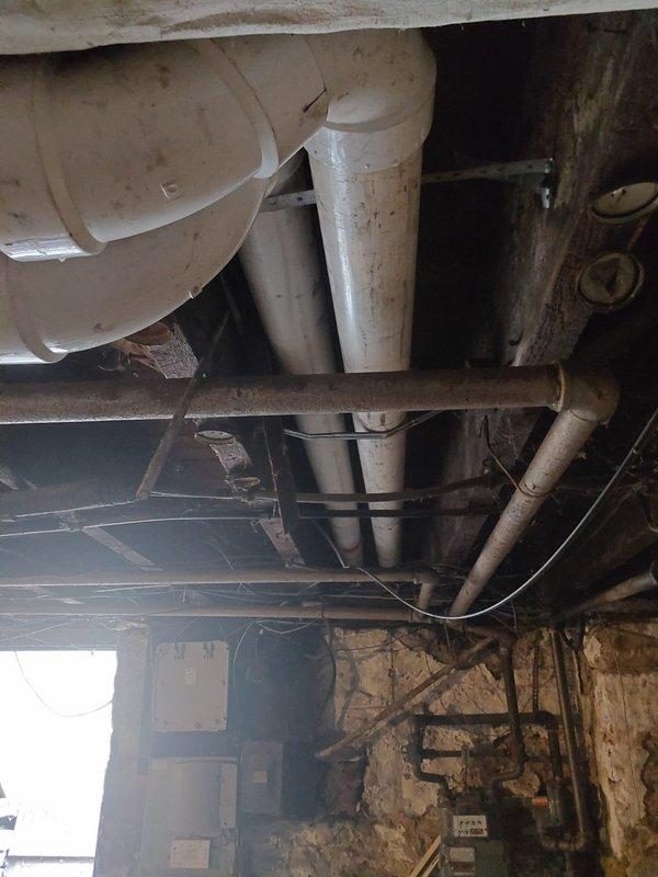 Responded to inspection correction requirements by relocating the union from inside the unit to the exterior as specified. Additionally, rerouted the venting system that was previously discharging onto neighboring property, installing new PVC piping to redirect exhaust to the appropriate side of the building per code requirements.