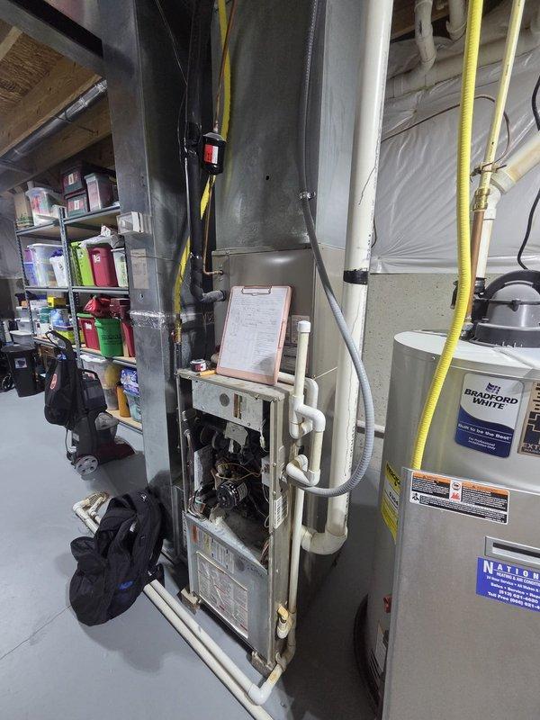 Performed inspection of non-functioning gas furnace exhibiting "no heat" condition. Diagnostic assessment revealed faulty inducer motor requiring complete system replacement. Documented existing installation configuration including Bradford White water heater, current ductwork, and ventilation setup to prepare comprehensive replacement estimate.