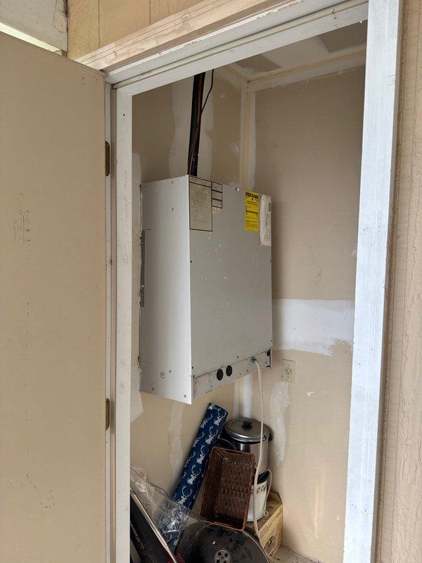 Responded to no cooling complaint at apartment unit. Upon arrival, inspected wall-mounted HVAC unit located in utility closet and verified electrical panel breaker configuration. Documented equipment location and electrical distribution panel with circuit identification for AC system. Photographed unit installation and breaker panel showing proper circuit labeling for furnace, AC, and associated electrical circuits.