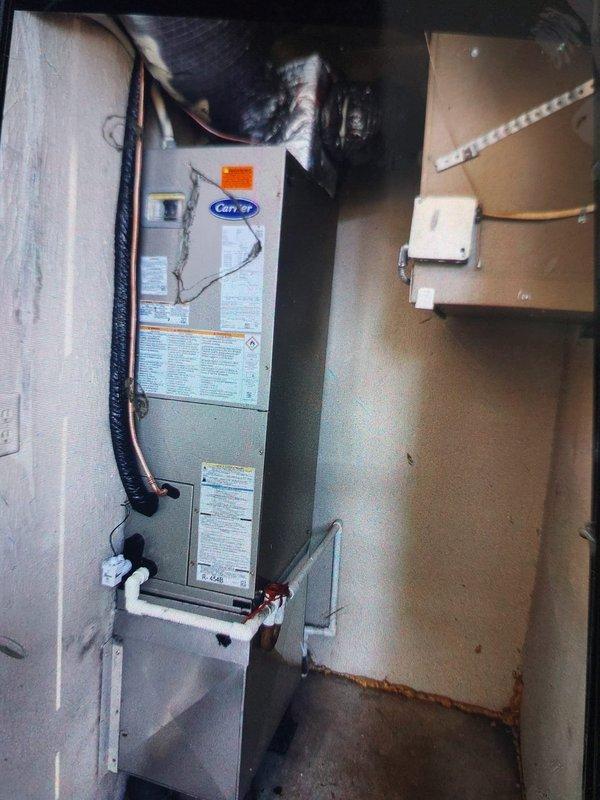 Completed installation of Carrier FJ5ANXA18L00 air handler unit with NCP5184000 8KW electric heater in commercial utility space. Installed new air handler vertically against wall with proper mounting and secured all electrical connections to existing breaker panel. Ran condensate drainage lines using white PVC piping from unit to approved drain location and installed black flexible supply ductwork from top of unit to existing distribution system. Verified all electrical circuits, tested heater operation at full capacity, and confirmed proper airflow through system. Unit operational and performing to manufacturer specifications.
