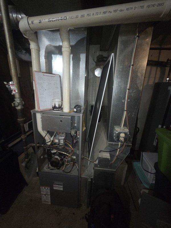 Conducted comprehensive assessment of existing HVAC system for replacement estimate. Evaluated indoor furnace unit with associated ductwork and PVC venting system located in basement utility area, documenting current equipment configuration and installation conditions. Inspected outdoor condensing unit positioned on concrete pad adjacent to structure, assessed electrical disconnect and conduit routing. Photographed both indoor and outdoor components to document existing system layout and facilitate accurate replacement proposal development.