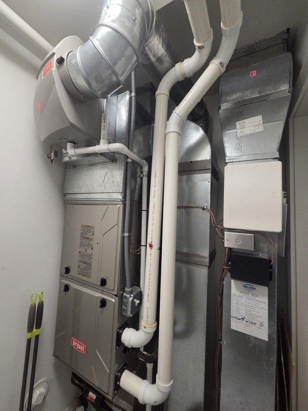 Conducted comprehensive assessment of existing HVAC system serving in-law suite to provide replacement estimate. Evaluated current Bryant furnace and air handler installation in utility closet, documenting equipment specifications, ductwork configuration, and thermostat setup. Inspected Bryant Evolution Connex thermostat, existing condensate drain lines, PVC venting system, and galvanized metal ductwork connections to determine compatibility requirements for new air conditioning unit installation.