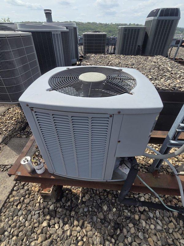 Completed estimate for air conditioning system replacement on rooftop installation. Assessed existing rooftop-mounted condenser unit and evaluated multiple HVAC units on gravel roof surface. Documented current thermostat configuration including White-Rodgers digital thermostat and Aprilaire dial-type thermostat for replacement system specifications.