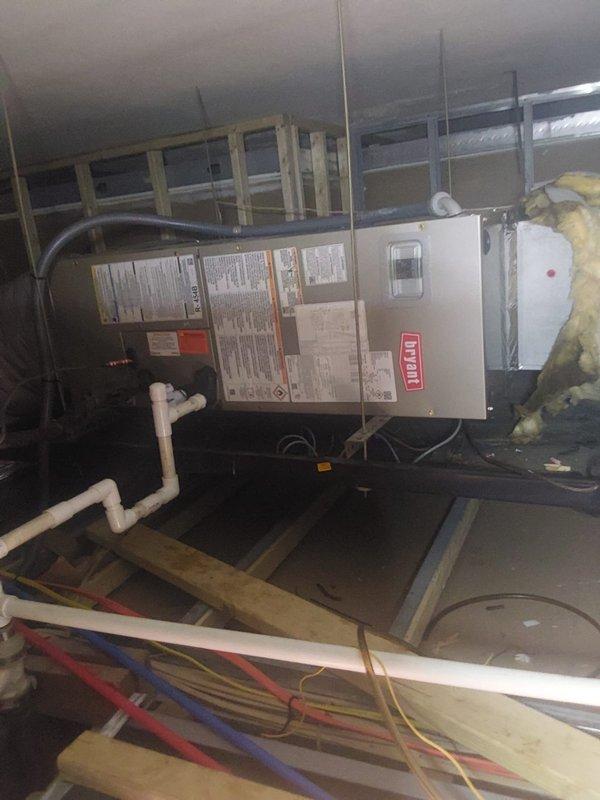 Completed full HVAC system installation for commercial apartment unit, including Bryant GH5SAN518 1.5-ton 15 SEER heat pump condensing unit installed on rooftop concrete pad, Bryant FJ5ANXA18L00 ceiling-mounted air handler in attic space with 8kW electric heat strip, and new programmable thermostat. Fabricated and installed custom sheet metal transitions to connect new equipment to existing supply and return ductwork, flushed refrigerant lines, and installed electrical disconnect with whip and fused connections. Added condensate drain pan with wet switch safety device under air handler, ran PVC condensate drainage, and mounted all equipment per manufacturer specifications. Removed and properly disposed of existing HVAC equipment in accordance with EPA refrigerant recovery regulations. System tested, charged to specification, and verified operational for both heating and cooling modes. All work completed under permit with final inspection approved.