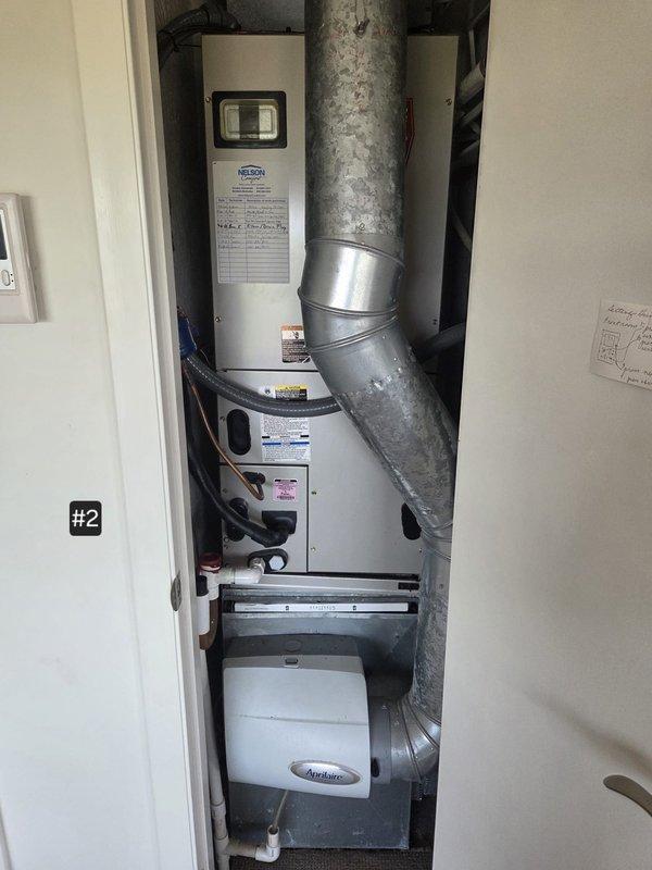 Completed heat pump system replacement for unit #2 located in upflow utility closet configuration. Replaced existing Bryant air handler (model 214DNL) with new equipment, including installation of associated ductwork modifications to accommodate 20" and 29" height specifications. Updated thermostat and replaced air filter with 16½" width unit, ensuring proper integration with existing Aprilaire humidifier system and galvanized metal ductwork.