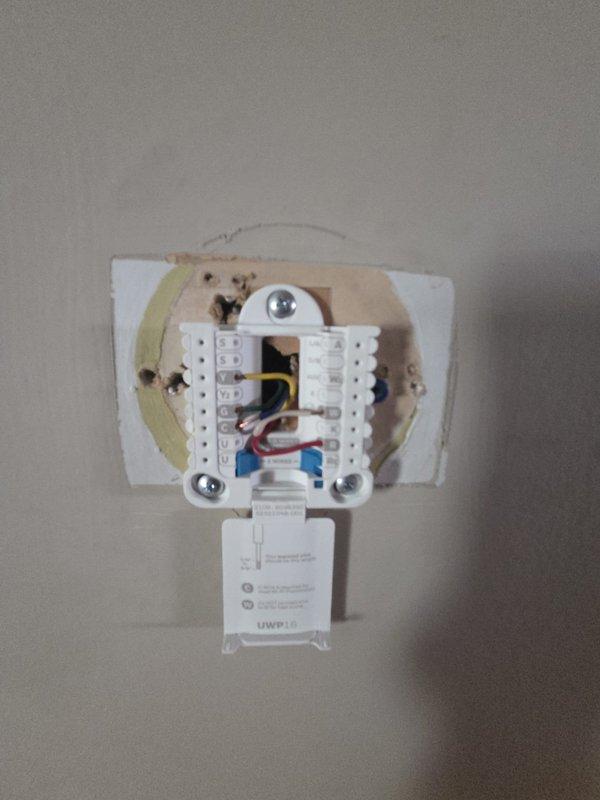 Conducted comprehensive assessment of existing HVAC system for complete replacement estimate. Evaluated gas furnace and air conditioning equipment located in basement installation. Documented current forced-air heating unit with gray metal casing, associated ductwork configuration, and PVC condensate drainage system. Inspected existing thermostat control wiring and terminal connections to determine compatibility requirements for new equipment installation. Photographed equipment specifications, spatial constraints, and existing infrastructure to develop accurate replacement proposal for complete heating and cooling system upgrade.
