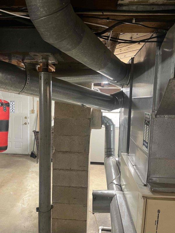 Conducted comprehensive assessment of existing residential HVAC system located in basement utility area for equipment replacement estimate. Evaluated current Nordyne furnace unit with connected galvanized metal plenum and ductwork distribution system. Inspected existing metallic ductwork network including cylindrical trunk lines, supply branches, and elbow configurations throughout the space. Documented equipment specifications, spatial constraints, and structural considerations including support column placement and ceiling joist clearances. Photographed current system configuration to provide detailed replacement recommendations and equipment sizing requirements.