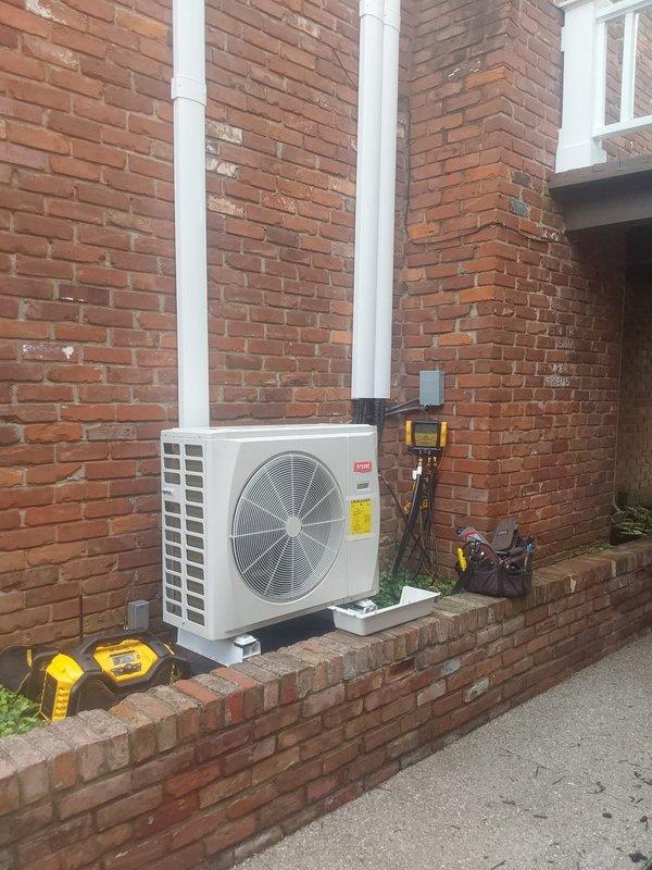Completed installation of a 1.5-ton Bryant ductless mini-split system for commercial application. Installed outdoor condensing unit on brick ledge with proper mounting, connected three Bryant high-wall indoor air handlers with refrigerant line sets and PVC condensate drainage routed vertically along exterior brick wall. Performed system startup, charged refrigerant to manufacturer specifications, tested all zones with digital manifold gauges to verify proper pressures and temperatures, and confirmed operational status of all thermostats and indoor units.