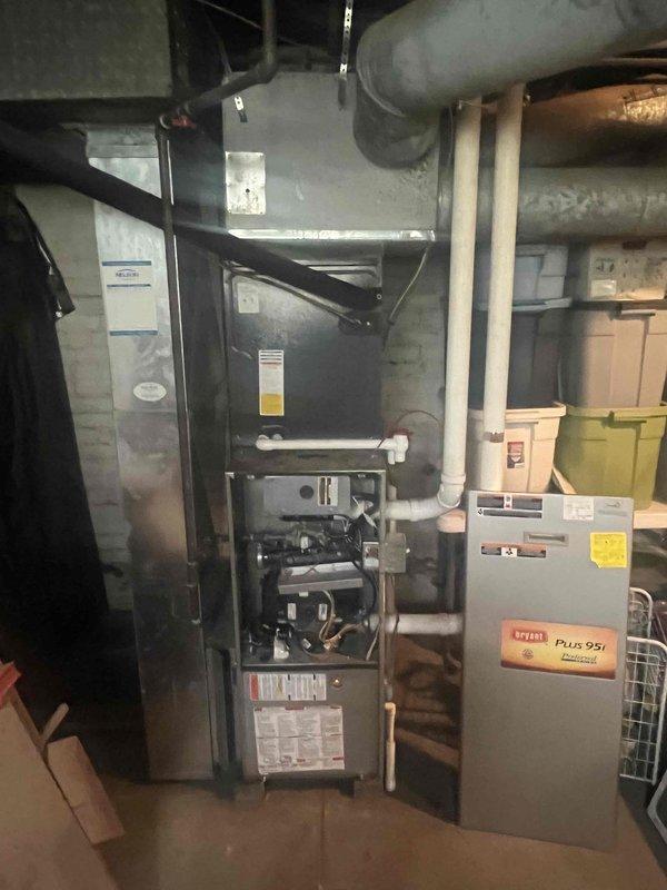 Provided estimate for complete furnace replacement on 2011 Bryant unit with failed heat exchanger. Inspected basement mechanical room and documented existing equipment condition, including exposed internal components with blower motor and compromised heat exchanger assembly. Assessed exterior HVAC system configuration with dual condensing units mounted on concrete pad against brick foundation. Presented replacement options to address safety concerns associated with cracked heat exchanger and restore reliable heating operation to the residence.