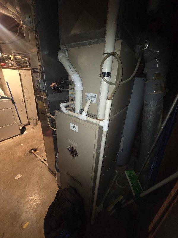 Completed estimate for replacement of 25-year-old gas furnace system located in basement utility area of bi-level residence. Assessed existing beige furnace unit with white PVC condensate and exhaust piping, along with adjacent water heater and ductwork configuration. Customer expressed interest in simultaneous furnace and air conditioning replacement to take advantage of combination system discount. Documented current equipment condition through photography, noting standard basement mechanical room layout with concrete flooring and typical utility connections. Provided comprehensive replacement options and pricing for coordinated HVAC system upgrade.