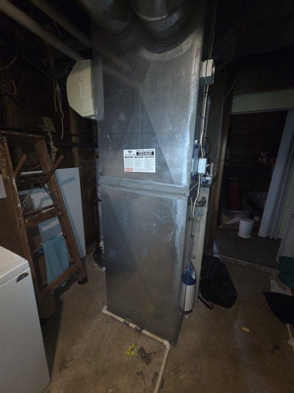 Completed estimate for replacement of 25-year-old gas furnace system located in basement utility area of bi-level residence. Assessed existing beige furnace unit with white PVC condensate and exhaust piping, along with adjacent water heater and ductwork configuration. Customer expressed interest in simultaneous furnace and air conditioning replacement to take advantage of combination system discount. Documented current equipment condition through photography, noting standard basement mechanical room layout with concrete flooring and typical utility connections. Provided comprehensive replacement options and pricing for coordinated HVAC system upgrade.