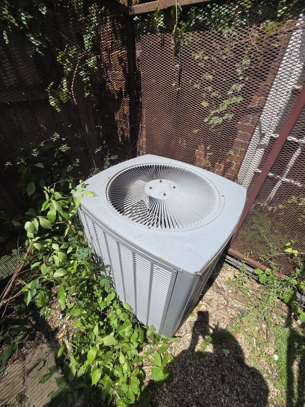 Provided comprehensive estimate for commercial HVAC system replacement at brick building facility. Evaluated existing outdoor condenser unit positioned on concrete pad near perimeter fencing, assessed current system capacity and condition, documented equipment specifications and installation requirements. Recommended replacement options for aging air conditioning system including proper sizing calculations, equipment specifications, and installation scope for new commercial-grade condensing unit with associated electrical and refrigerant line modifications.