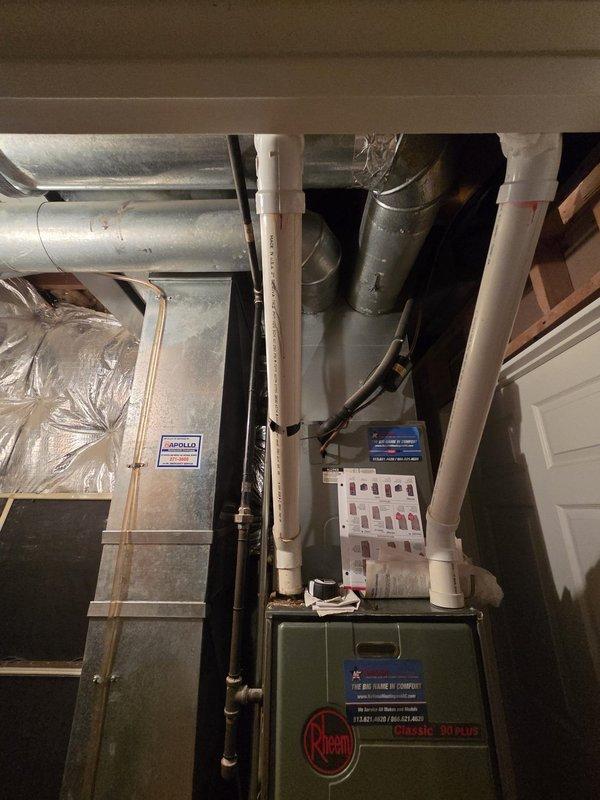 Conducted on-site evaluation of existing HVAC system for air conditioning replacement estimate. Assessed current equipment configuration including Rheem furnace, existing ductwork infrastructure, and climate control components consisting of Honeywell thermostat and Aprilaire humidistat. Documented equipment specifications, spatial constraints in mechanical room, and photographed existing installation including refrigerant line routing, PVC condensate drainage, and supply/return duct layout to determine replacement system requirements and compatibility.