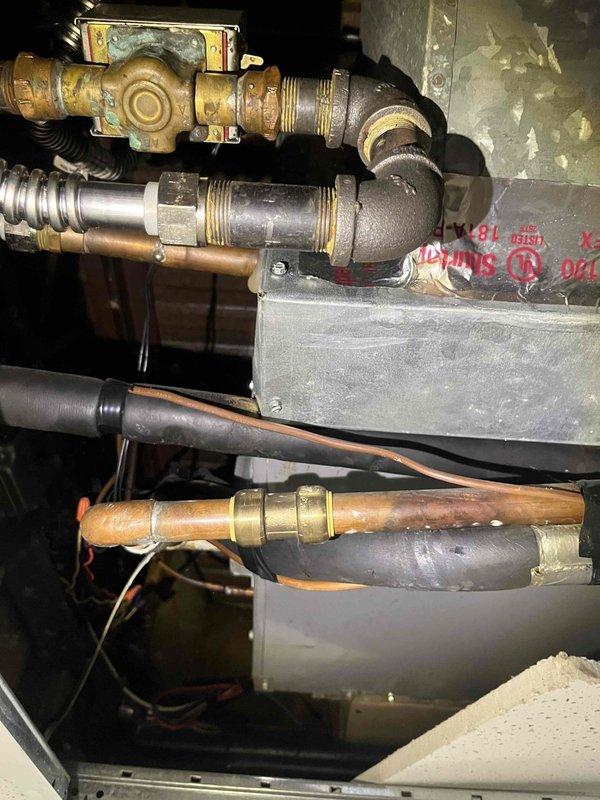 Conducted commercial air conditioning replacement estimate and documented existing mechanical infrastructure. Inspected gas valve assembly, piping connections, and associated HVAC components in utility space, photographing brass valve fittings, flexible gas connectors, copper distribution lines, and equipment mounting configuration to provide accurate replacement specifications.