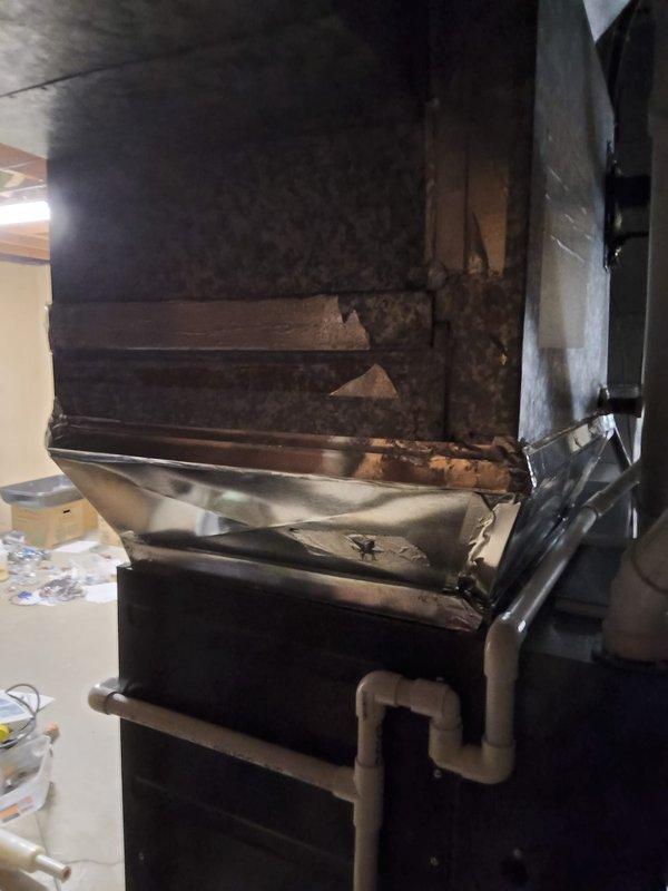 Conducted replacement estimate for 15-year-old residential air conditioning system serving a 4-bedroom home. Unit exhibited low refrigerant levels, though compressor and fan motor remained operational. Documented existing HVAC infrastructure including metal ductwork system showing age-related deterioration, warping, discoloration, and previous repair attempts with foil tape, as well as current rigid and flexible duct configurations in mechanical space. Provided assessment comparing repair versus full system replacement options given unit age and current condition.
