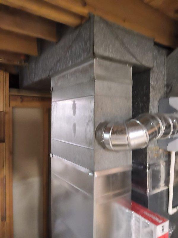 Conducted replacement estimate for 15-year-old residential air conditioning system serving a 4-bedroom home. Unit exhibited low refrigerant levels, though compressor and fan motor remained operational. Documented existing HVAC infrastructure including metal ductwork system showing age-related deterioration, warping, discoloration, and previous repair attempts with foil tape, as well as current rigid and flexible duct configurations in mechanical space. Provided assessment comparing repair versus full system replacement options given unit age and current condition.
