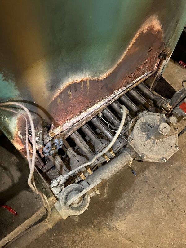 Completed commercial boiler estimate for vacant property under 4,000 square feet. Inspected existing gas-fired heating unit with multi-tube burner assembly and blower motor; system currently operational. Documented significant water damage and deterioration on walls surrounding equipment, including rust-colored staining and peeling surfaces indicating potential moisture intrusion issues that may require attention.