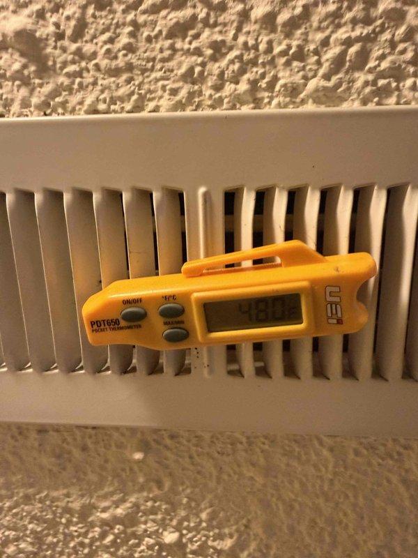 Responded to callback for HVAC system installed in October with reported lack of air conditioning. Performed diagnostic inspection and temperature measurements at baseboard heating unit using calibrated digital thermometer. Verified thermostat operation and confirmed heating system functionality with unit set to 50 degrees while indoor temperature registered 69 degrees.