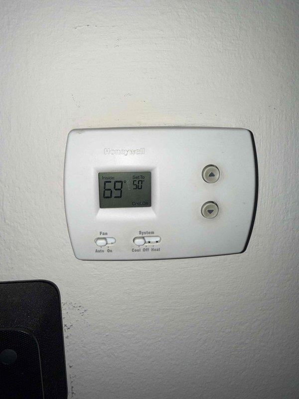 Responded to callback for HVAC system installed in October with reported lack of air conditioning. Performed diagnostic inspection and temperature measurements at baseboard heating unit using calibrated digital thermometer. Verified thermostat operation and confirmed heating system functionality with unit set to 50 degrees while indoor temperature registered 69 degrees.