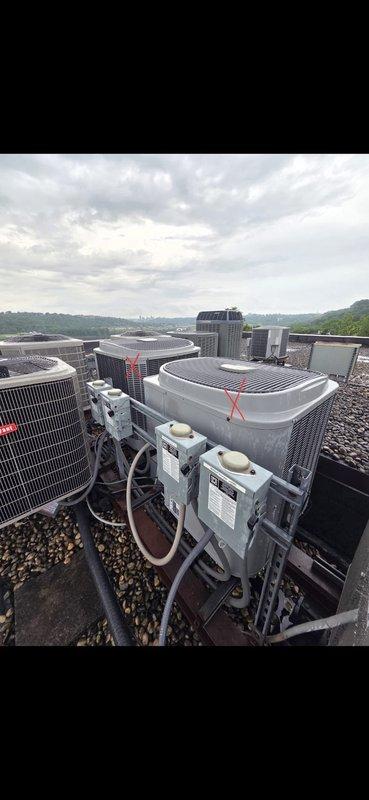 Conducted comprehensive site assessment for HVAC system replacement at residential property. Evaluated existing rooftop equipment including multiple condensing units and air handlers, noting unit marked for replacement. Documented current indoor control system configuration including Aprilaire humidistat and White-Rodgers digital thermostat displaying operational temperatures. Assessed refrigerant line routing, electrical conduit connections, and equipment accessibility on gravel-surfaced roof. Provided replacement estimate for aging HVAC equipment based on system evaluation and performance requirements.