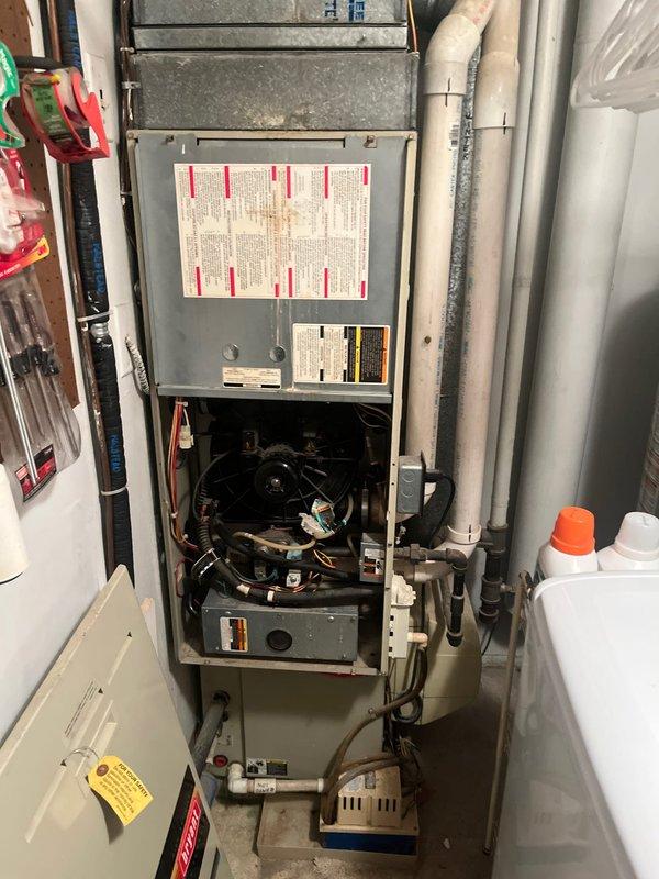 Conducted comprehensive assessment of existing residential HVAC system for replacement estimate. Evaluated gas furnace unit located in interior utility closet, documenting internal components including blower motor, burner assembly, and electrical connections showing normal operational wear. Inspected outdoor air conditioning condenser unit positioned on concrete pad against exterior brick wall, noting significantly deteriorated fan guard with extensive rust and corrosion requiring attention. Photographed both units to document current system condition and discussed available replacement options with homeowner, including energy-efficient upgrade opportunities for complete heating and cooling system.