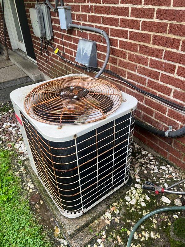 Conducted comprehensive assessment of existing residential HVAC system for replacement estimate. Evaluated gas furnace unit located in interior utility closet, documenting internal components including blower motor, burner assembly, and electrical connections showing normal operational wear. Inspected outdoor air conditioning condenser unit positioned on concrete pad against exterior brick wall, noting significantly deteriorated fan guard with extensive rust and corrosion requiring attention. Photographed both units to document current system condition and discussed available replacement options with homeowner, including energy-efficient upgrade opportunities for complete heating and cooling system.