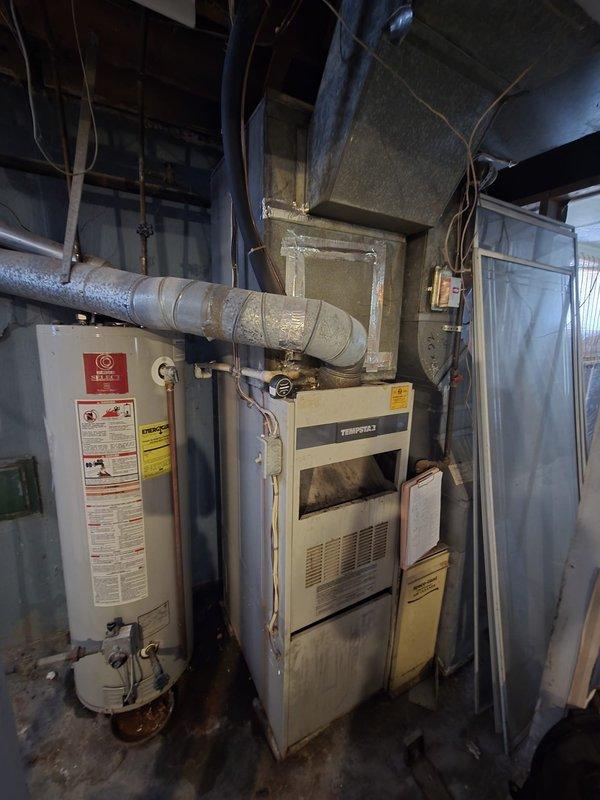Completed comprehensive HVAC system replacement estimate for existing Tempstar furnace and associated equipment. Documented current electrical panel configuration with main breaker and branch circuits, photographed existing aging furnace unit with ductwork connections, water heater placement, and utility room layout to provide accurate assessment for complete system upgrade.