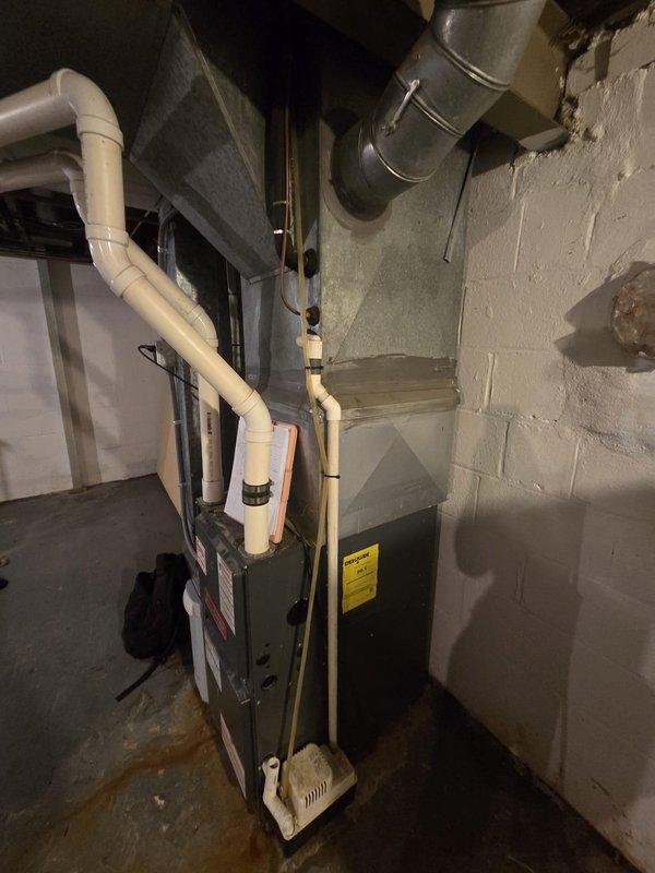 Conducted estimate for complete air conditioning system replacement in small residential property. Existing AC unit from late 1980s/early 90s failed last year and requires full replacement, while existing 5-10 year old furnace remains operational and in serviceable condition. Assessed basement mechanical room installation, documented current HVAC configuration including furnace, ductwork, PVC venting system, and electrical connections to determine replacement specifications and compatibility requirements.