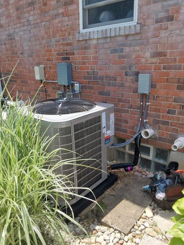 Completed full HVAC system installation including a 5-ton two-stage 148TAN06000W Preferred air conditioning condenser unit utilizing R454B refrigerant and a CVAVA6021XMA V-coil cased vertical evaporator coil. Installed outdoor condenser unit on concrete pad against exterior brick wall, ran refrigerant line set through wall penetration, mounted electrical disconnect and conduit, established proper electrical connections, and completed all necessary wiring per manufacturer specifications. Installed new digital programmable thermostat with configuration of system settings for two-stage operation. Performed complete system startup, verified proper refrigerant charge, tested all electrical connections, confirmed correct airflow across evaporator coil, and validated two-stage compressor operation. System is operating within manufacturer specifications with proper temperature differential and all safety controls functioning correctly.