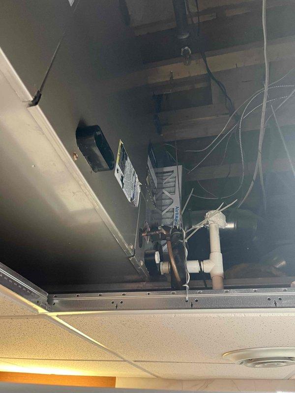 Conducted comprehensive site assessment for commercial HVAC system replacement at multi-story brick institutional building. Documented existing air handler unit located in ceiling plenum space, noting current equipment configuration, ductwork connections, electrical wiring, and structural access points. Provided detailed photographic documentation of existing mechanical equipment and building exterior to support replacement estimate preparation.