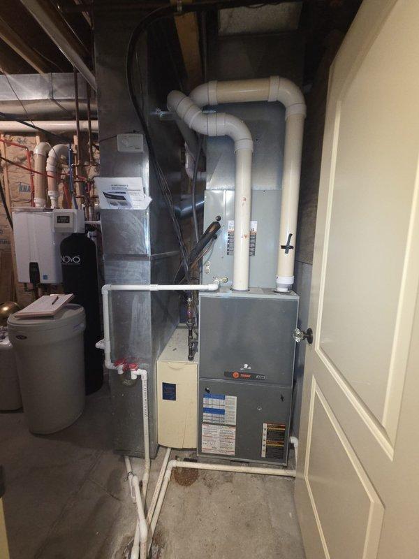 Conducted comprehensive assessment of existing residential HVAC system for replacement of two air conditioning units. Evaluated current Bryant furnace installation, associated ductwork configuration, and integrated humidification system in mechanical room. Documented existing equipment specifications, condensate drainage lines, PVC venting systems, and electrical connections. Inspected flexible and rigid ductwork routing, air handler components, and system controls to determine compatibility requirements for new AC unit installations. Photographed current setup including furnace positioning, plumbing connections, and available workspace for equipment replacement planning.