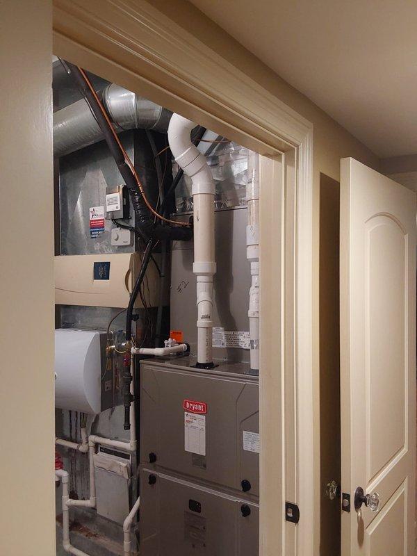 Completed dual-zone HVAC installation consisting of two 146SAN air conditioning systems (3.0-ton and 5.0-ton single-stage units utilizing R454B refrigerant) with corresponding CVAVA V-coil cased vertical evaporator coils installed in interior utility closet alongside existing furnace. Both outdoor condensing units positioned on exterior foundation pad with proper refrigerant line sets, electrical connections, condensate drainage routing via PVC piping, and all systems tested for proper operation and refrigerant charge.