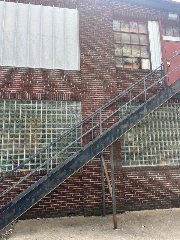 Conducted site evaluation for potential mini split installation in commercial office space currently lacking air conditioning. Assessed interior office layout with multiple workstations and exterior building access points on red brick structure, documented conditions, and provided estimate for ductless HVAC system to serve the workspace.