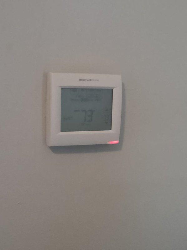 Conducted comprehensive assessment of existing residential cooling system, including indoor Honeywell Home digital thermostat and outdoor condenser unit with protective grille positioned on gravel pad between exterior walls. Documented current equipment condition through detailed photography and provided replacement estimate for complete HVAC system upgrade.