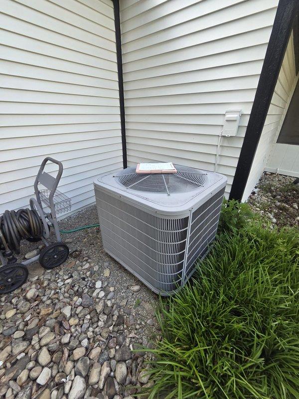 Conducted comprehensive assessment of existing residential cooling system, including indoor Honeywell Home digital thermostat and outdoor condenser unit with protective grille positioned on gravel pad between exterior walls. Documented current equipment condition through detailed photography and provided replacement estimate for complete HVAC system upgrade.