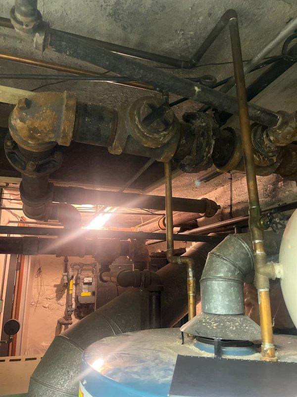 Removed and disposed of existing boiler system from basement mechanical room. Installed new Weil McLain LGB-4 atmospheric gas boiler with steam trim, completing all near boiler piping to manufacturer's specifications. Replaced four 17C thermostatic radiator controls throughout the property to ensure proper system operation and temperature regulation.