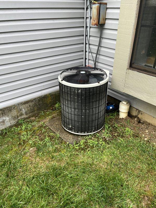 Completed estimate for air conditioning system replacement at residential property. Evaluated existing outdoor condenser unit showing signs of age and weathering, with visible algae staining on adjacent siding, and assessed indoor air handler compatibility and ductwork condition. Documented current system configuration including refrigerant line routing and electrical disconnect location, provided replacement options and recommendations for complete HVAC system upgrade.