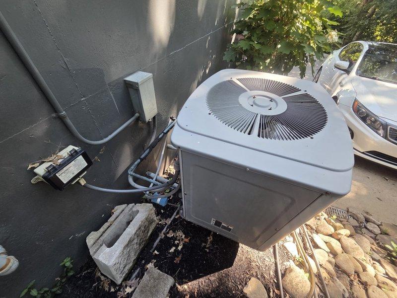 Conducted comprehensive evaluation of existing residential HVAC system for complete replacement estimate. Assessed outdoor condensing unit positioned on concrete pad with existing refrigerant lines and electrical disconnect. Evaluated indoor furnace installation in basement, documenting equipment dimensions and clearances including 36" air handler height, 24.5" and 40" furnace measurements, and 28" side clearance. Noted existing 26x10 return air configuration, 8x20 ductwork with limited accessibility to remaining duct runs, and identified need for filter rack replacement and new humidifier installation. Photographed both outdoor and indoor equipment locations to document current system configuration and spatial constraints for replacement planning.