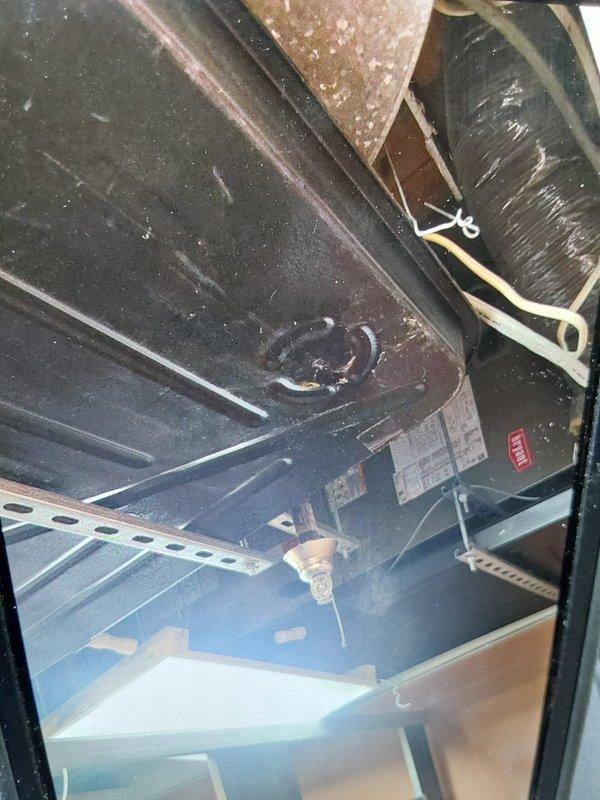 Installed drip pans on commercial HVAC air handling unit located in confined mechanical space. Accessed equipment compartment, positioned and secured drip pans beneath evaporator coil assembly using appropriate mounting brackets and hardware to prevent condensate overflow and potential water damage. Work completed on time and material basis with all components properly installed and secured.