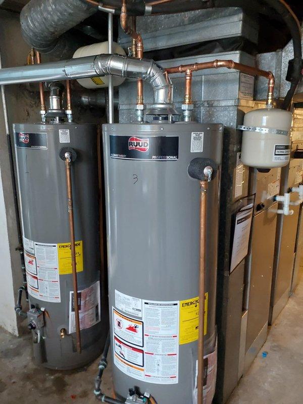 Completed commercial water heater replacement involving removal and disposal of existing water heating equipment and installation of four PROG403 40-gallon gas water heaters in a basement mechanical room. All units were elevated on blocks per specifications and connected with new copper piping, fittings, and necessary gas lines. The existing expansion tank was inspected, tested, and successfully reused in the new configuration. All plumbing connections were completed with proper venting, including metallic ductwork and insulated piping runs. Temperature and pressure relief valves were installed on each unit, and all gas control assemblies were properly configured with safety controls and temperature regulation devices. System was tested for proper operation, leak-free connections, and adequate combustion. All four water heaters are now operational and functioning within manufacturer specifications.