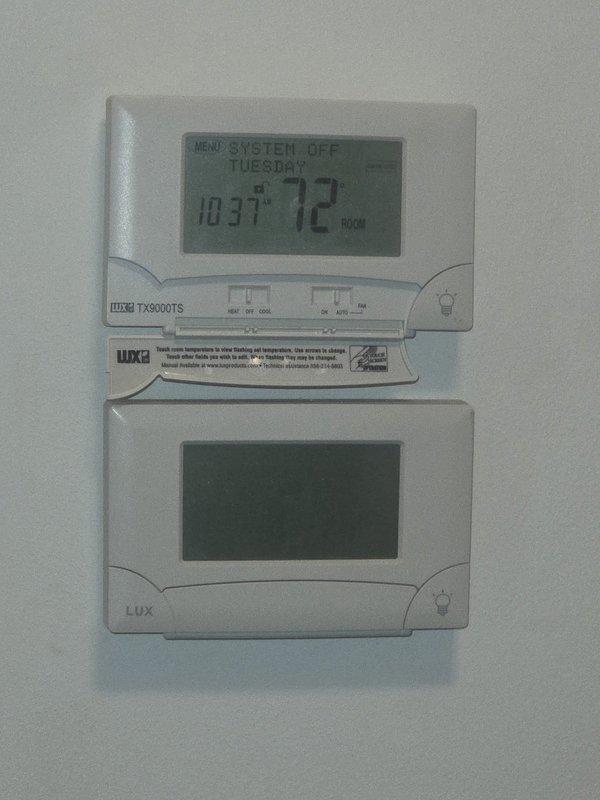Conducted on-site estimate for heat pump replacement with inverter system technology. Evaluated existing equipment installation including dual-zone thermostat configuration with Luxpro TX9000TS programmable controls and assessed exterior condensing unit location adjacent to basement stairwell access. Documented current system layout, exterior refrigerant line routing along brick exterior wall, and provided customer with inverter heat pump replacement options and specifications.