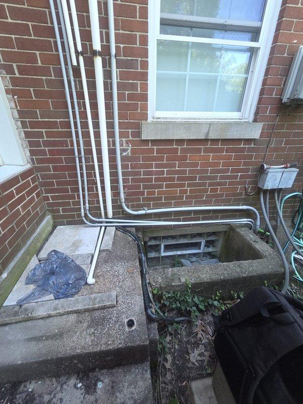 Conducted on-site estimate for heat pump replacement with inverter system technology. Evaluated existing equipment installation including dual-zone thermostat configuration with Luxpro TX9000TS programmable controls and assessed exterior condensing unit location adjacent to basement stairwell access. Documented current system layout, exterior refrigerant line routing along brick exterior wall, and provided customer with inverter heat pump replacement options and specifications.