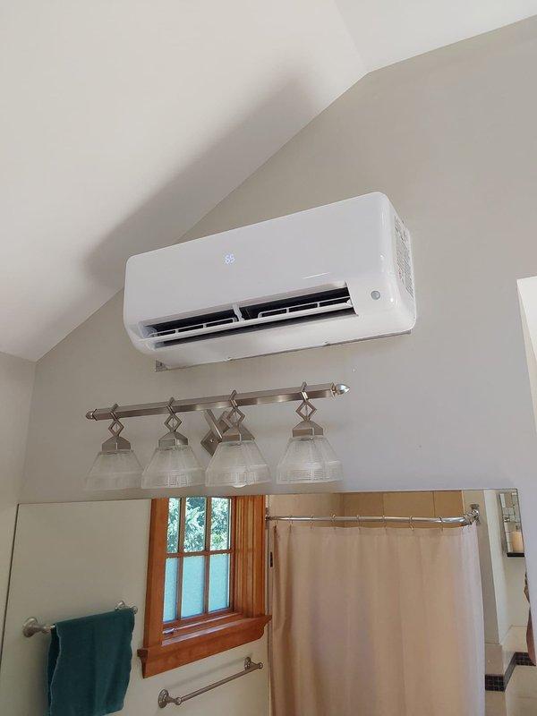 Completed installation of Bryant ductless mini-split system consisting of one 37MGHAQ18CA3 1.5-ton outdoor condensing unit and two D5MAHAQ09XA3 high-wall indoor air handlers. Installed new equipment pad for outdoor unit, ran electrical whip to unit, and mounted disconnect box with fuses on exterior brick wall. Flushed and reused existing line sets to connect indoor units to outdoor condenser. Mounted one indoor unit in bathroom near ceiling and positioned outdoor unit on pad with landscaping. System tested and operational with 10-year parts and labor warranty coverage.