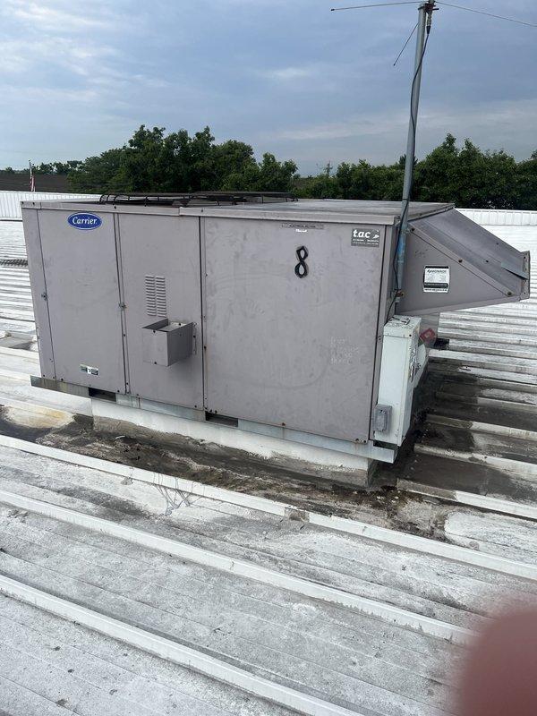 Conducted site assessment of commercial rooftop Carrier package unit model 48TJD024-6A1AA for replacement quote. Documented existing equipment condition, mounting configuration, and accessibility on white ribbed metal roof with photographic evidence showing weathering and operational history of unit #8.