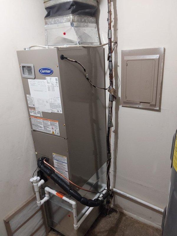 Completed full commercial HVAC system installation consisting of Bryant FJ5ANXA18L00 air handler with 10 kW heating element and Bryant GA4SAN518 outdoor condensing unit. Installed air handler in interior utility space with proper ductwork connections including metallic plenum and flexible ducting at supply outlet. Ran and terminated electrical wiring from wall-mounted disconnect to air handler, securing all conduit and wiring per code requirements. Installed PVC condensate drain lines from air handler base with proper pitch and termination. Mounted outdoor condensing unit on concrete pad against exterior brick wall alongside existing HVAC equipment. Installed electrical disconnect box on brick wall with conduit run to condensing unit. Connected refrigerant line set between indoor and outdoor units. Installed whip connection and fuses at disconnect location. Verified all electrical connections, tested system operation, and confirmed proper airflow and drainage.