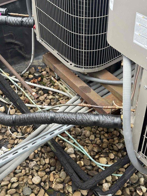 Responded to inspection callback for heat pump refrigerant line insulation correction. Upon arrival, verified multiple heat pump units on rooftop installation with inadequate or deteriorating line insulation on refrigerant piping. Inspected all refrigerant lines running between condenser units and observed foam insulation with tears, wear, and exposed copper piping in several locations. Applied proper insulation to all exposed refrigerant lines per manufacturer specifications and code requirements. Documented completed work with photographs showing corrected insulation on all heat pump refrigerant lines. System ready for final inspection approval.