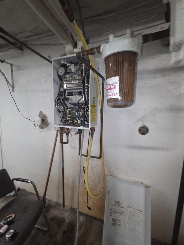 Conducted on-site assessment of existing Navien NR-240 NG tankless water heater in mechanical room to provide replacement estimate. Inspected unit with front panel open to evaluate internal components, circuit boards, wiring, and copper piping connections. Documented current installation including water filtration system, gas line configuration, and venting requirements for replacement specifications.