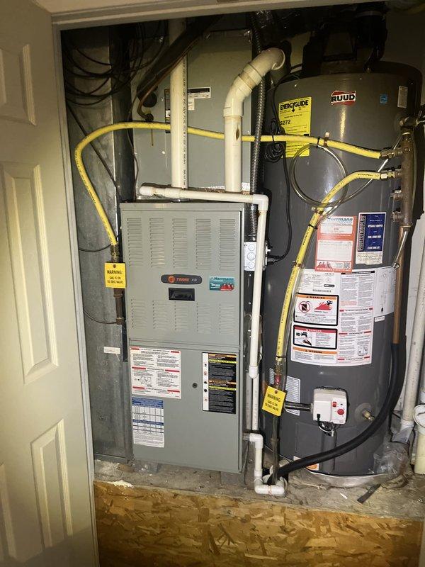 Completed estimate for air conditioning system replacement at residential property. Evaluated existing Trane HVAC unit and associated mechanical equipment located in interior utility closet, including air handler, ductwork connections, and integrated systems. Assessed current installation configuration with white PVC condensate piping, flexible duct connections, electrical wiring, and gas line routing to provide comprehensive replacement options and recommendations.