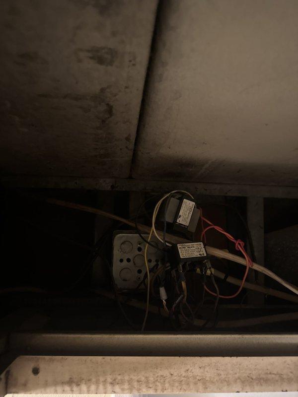 Responded to no cooling complaint at commercial property. Upon arrival, accessed unit and inspected mechanical compartment and internal components. Found signs of age and wear throughout system including staining on interior surfaces and dust accumulation. Examined electrical controls, relays, and wiring connections within compartment. Documented unit condition with photos showing copper refrigerant lines, control module, and electrical components for service records.