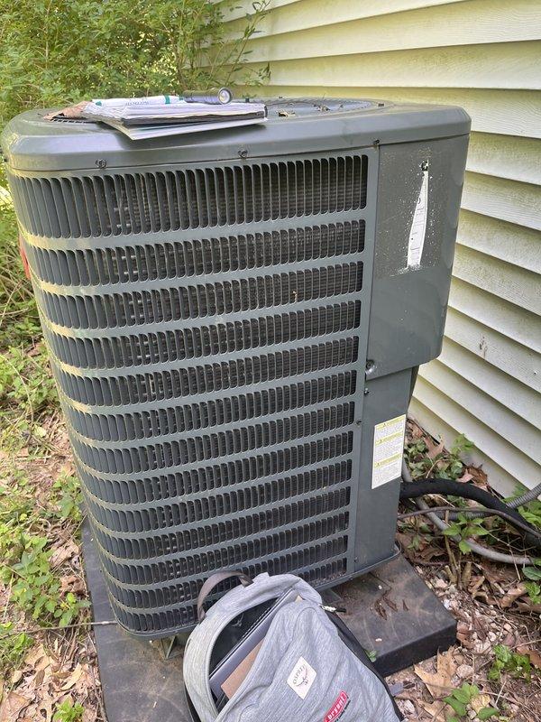Conducted comprehensive assessment of two outdoor air conditioning condenser units for replacement estimate. Both units showed significant age-related deterioration with weathered casings, discoloration, and grime accumulation. Documented existing equipment conditions including unit positioning on concrete pads, electrical disconnect boxes, refrigerant line routing, and conduit installations. Noted substantial environmental factors affecting equipment including algae growth on building siding, vegetation encroachment around unit bases, and inadequate clearance maintenance that could impact future system performance and serviceability.